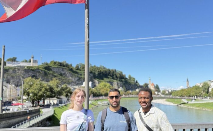 Auszubildende der Berufsfachschule Pflege auf einer Brücke. Über ihnen weht eine österreichische Flagge