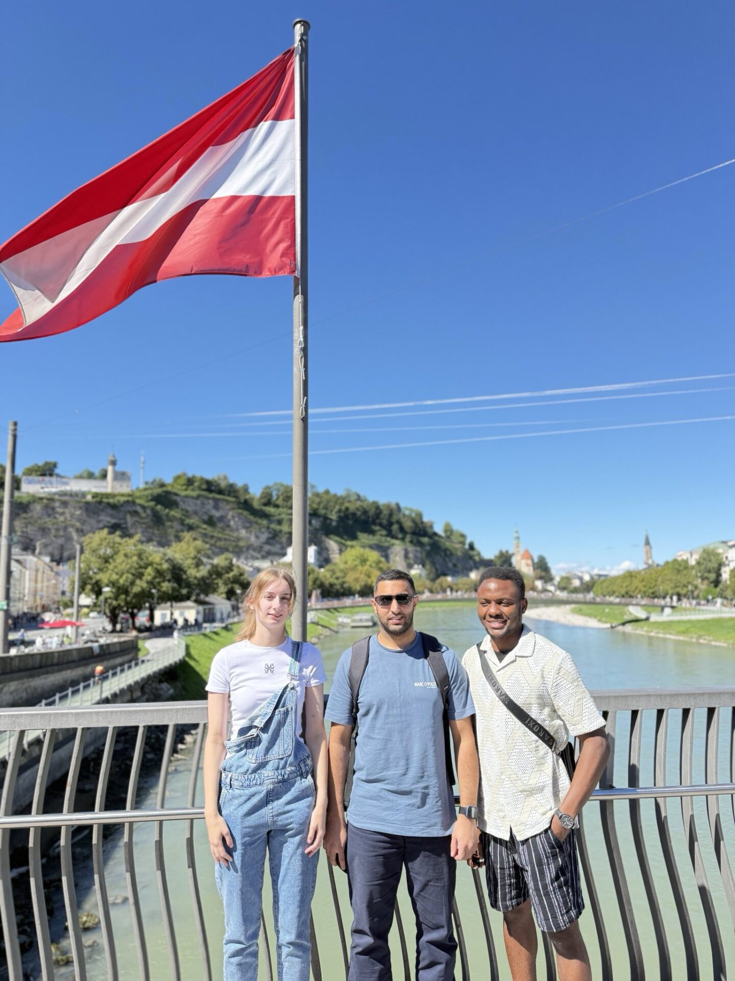 Auszubildende der Berufsfachschule Pflege auf einer Brücke. Über ihnen weht eine österreichische Flagge