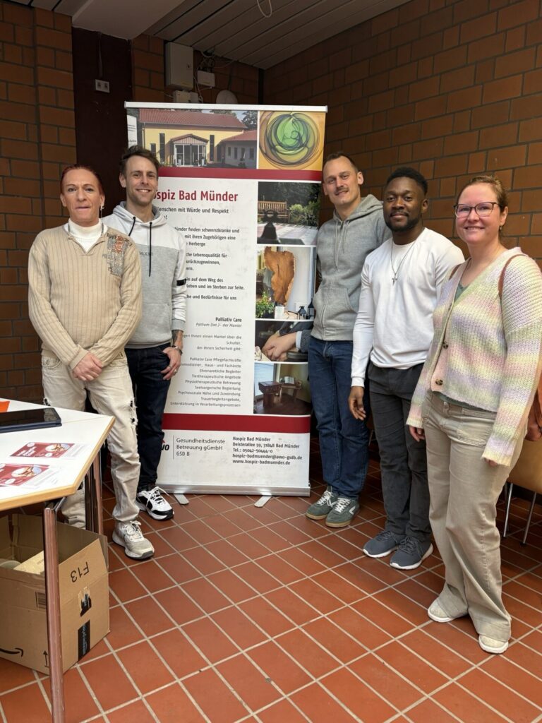 Eine Gruppe Menschen steht vor einem Info-Banner des Hospiz Bad Münder